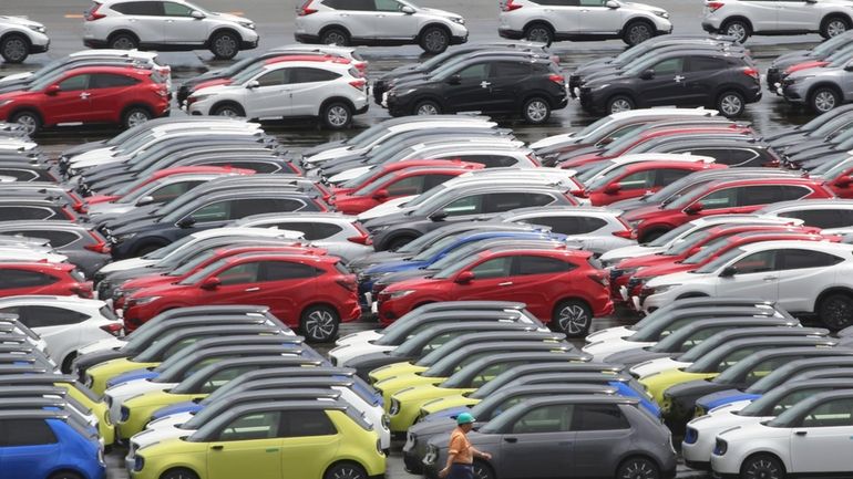 Cars for export are parked at a port in Yokohama,...