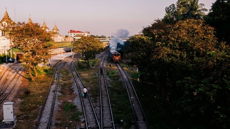 A train leaves Central Railway Station at dusk in Yangon,...