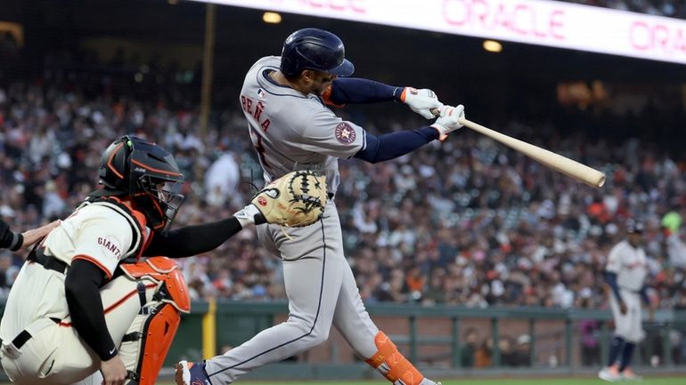 Houston Astros' Jeremy Peña, right, hits an RBI sacrifice fly...