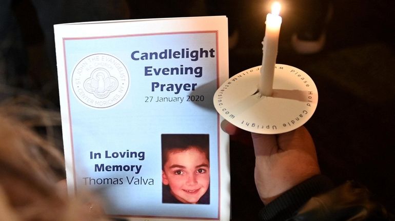 A woman attends a candlelight vigil for Thomas Valva at...