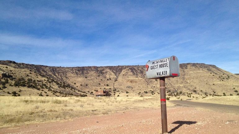 A single mailbox stands at the base of Black Mesa...