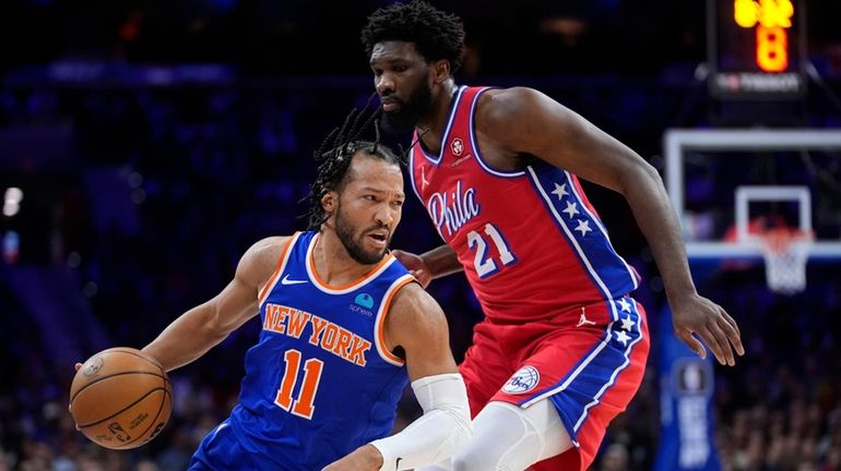 The Knicks' Jalen Brunson, left, gets past the 76ers' Joel...