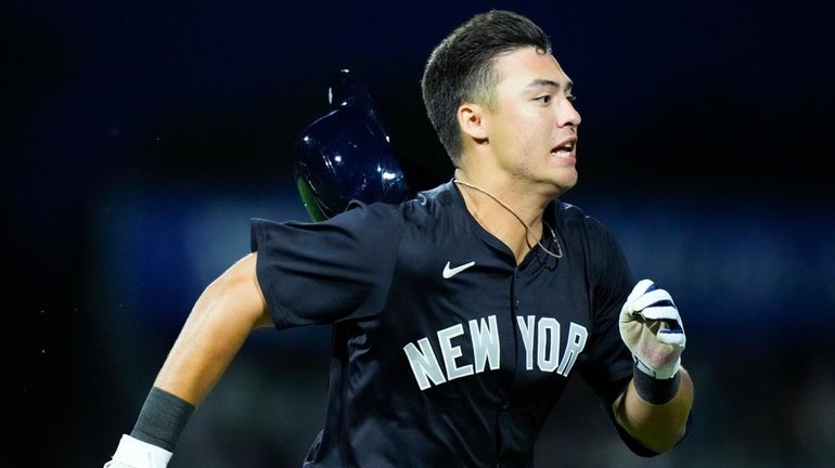 Anthony Volpe of the Yankees runs to first base against...