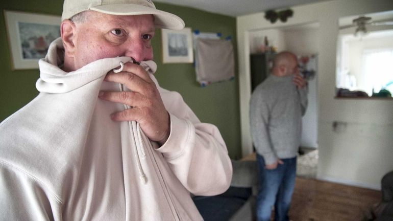 Richard Barone, left, and his neighbor Mike Beharovic, right, try...