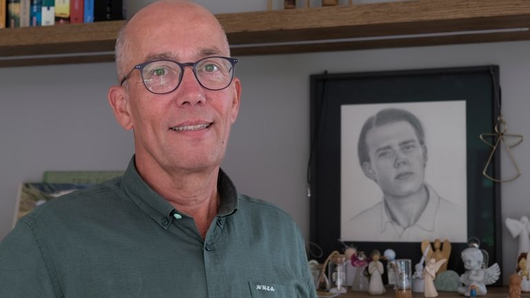 Thomas Schansman poses in front of a drawing of his...