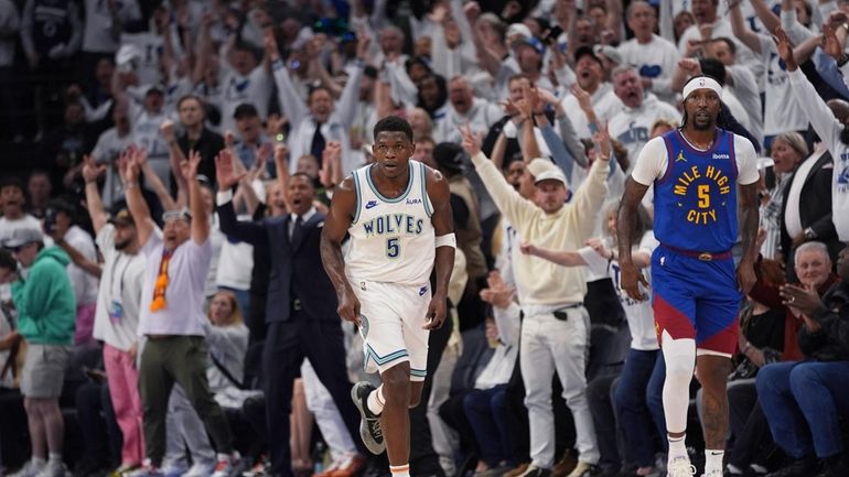 Minnesota Timberwolves guard Anthony Edward, left, runs down the court...