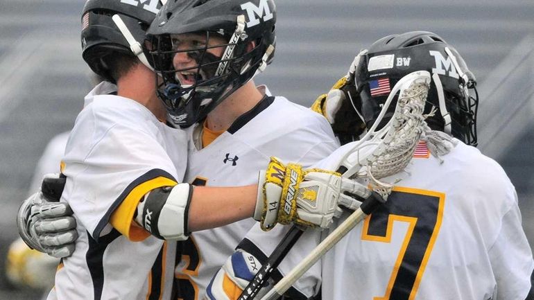 Massapequa High School's Ian Kirby, center, gets congratulated by teammates...