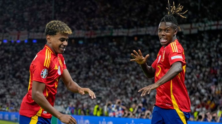 Spain's Nico Williams, right, celebrates with his teammate Lamine Yamal...