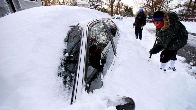 Shahhan Raheel, 11, of Central Islip, digs out his parents'...