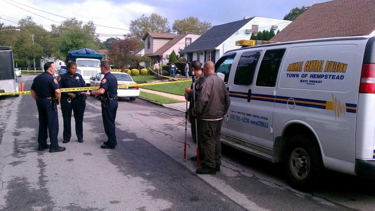 Nassau County police and Animal Control officials stand on West...