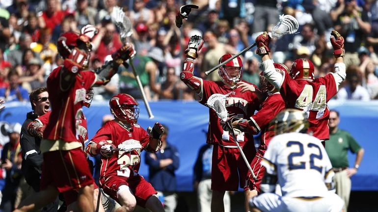 Denver's Wesley Berg (14) raises his arms as his teammates...