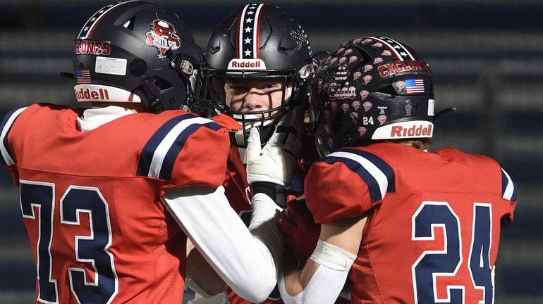 AJ Magaraci of South Side, center, gets congratulated by teammates...