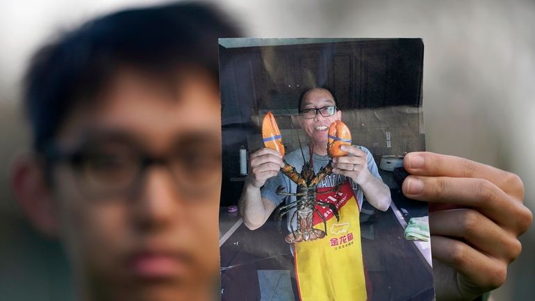 Harrison Li holds a photo of his father, Kai Li,...