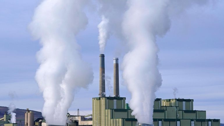 Steam billows from a coal-fired power plant Nov. 18, 2021,...