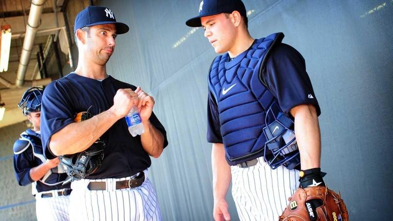 Catcher Russell Martin, right, speaks with Jorge Posada, left, during...