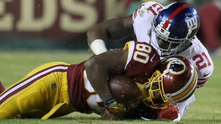 Giants safety Landon Collins, right, takes down Redskins receiver Jamison...