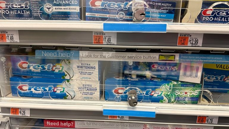 Tubes of toothpaste are displayed behind a locked, plastic barrier...