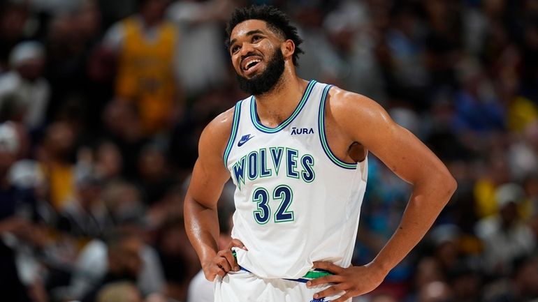 Minnesota Timberwolves center Karl-Anthony Towns reacts after being called for...