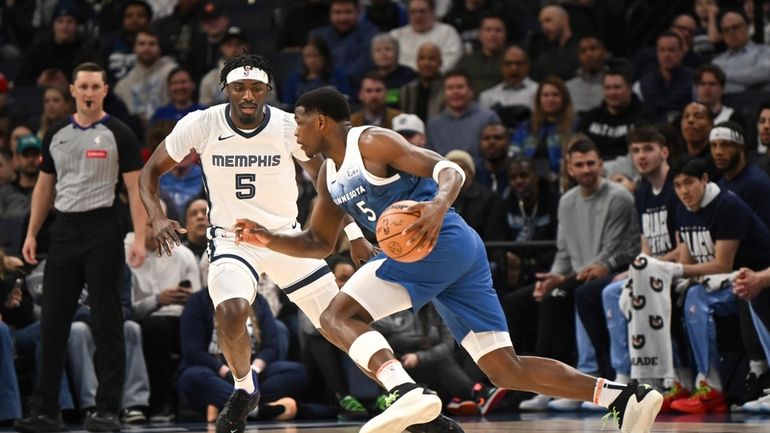 Minnesota Timberwolves guard Anthony Edwards, right, drives past Memphis Grizzlies...