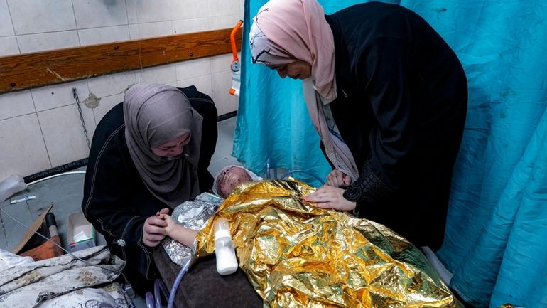 Amal Abdel-Hadi, left, and Nour Abdel-Hadi, right, react over their...