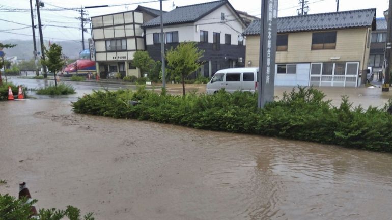 A road is flooded after heavy rain in Wajima, Ishikawa...