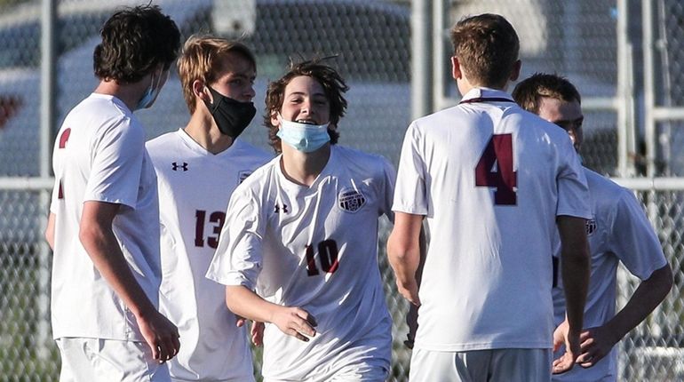 Garden City's Tommy Poz (10) is congratulated after scoring the...