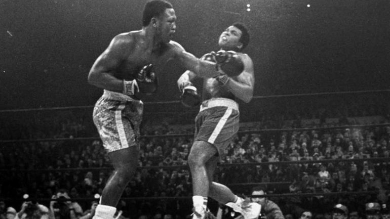 Joe Frazier hits Muhammad Ali with a left during the...