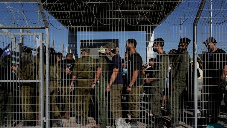 Israeli soldiers gather at the gate to the Sde Teiman...