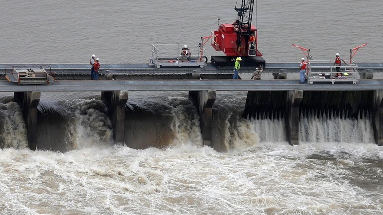 Workers open bays of the Bonnet Carre Spillway to divert...