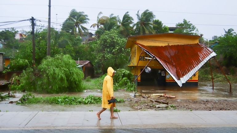 A person walks in the rain after the passing of...