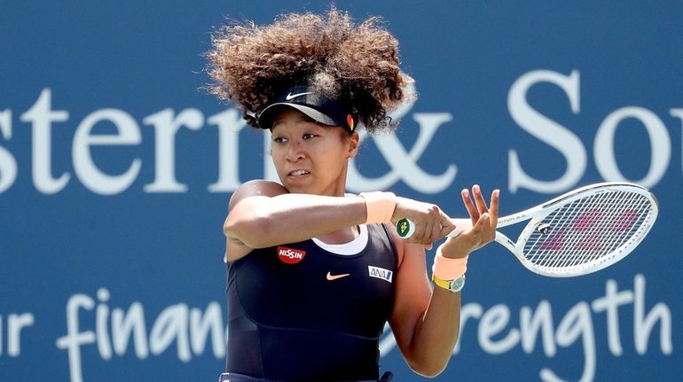 Naomi Osaka returns a shot to Elise Mertens during the...