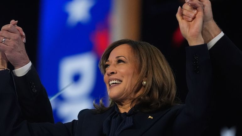 Democratic presidential nominee Vice President Kamala Harris celebrates with her...