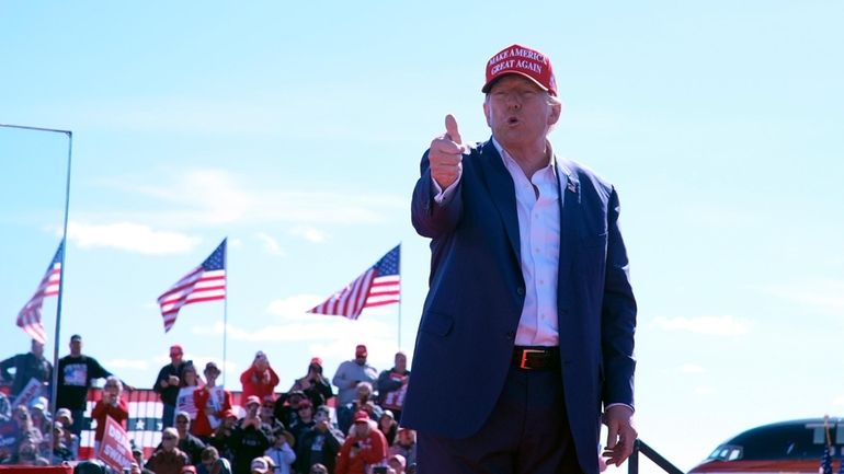 Republican presidential nominee former President Donald Trump gestures as he...