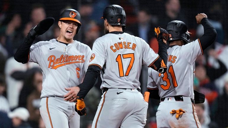 Baltimore Orioles' Colton Cowser, center, is congratulated by Ryan Mountcastle...