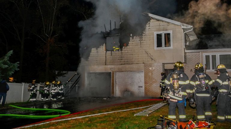 Firefighters at a house fire on Piper Drive in Searingtown early Tuesday...