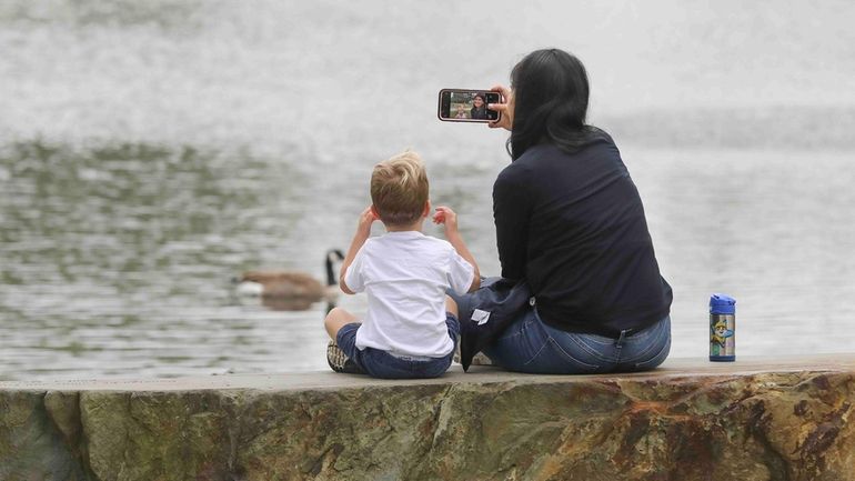 At the pond in Huntington's Heckscher Park, caretaker Ariadna Lopez takes...