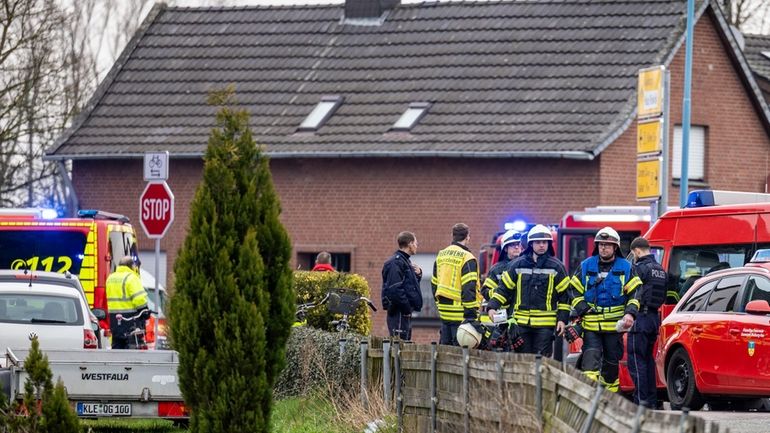 Police and fire department personnel stand by a retirement home...