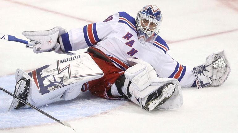 Rangers goaltender Henrik Lundqvist scrambles after making a save against...