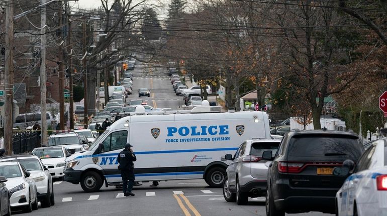 Police vehicles are parked near the scene of the predawn shooting...