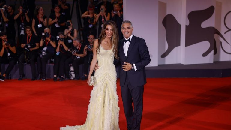 Amal Clooney, left, and George Clooney pose for photographers upon...