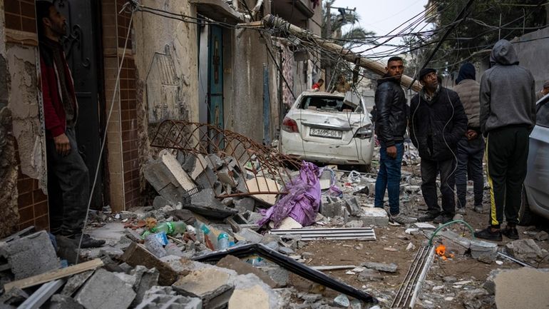 Palestinians look at the destruction after an Israeli airstrike in...