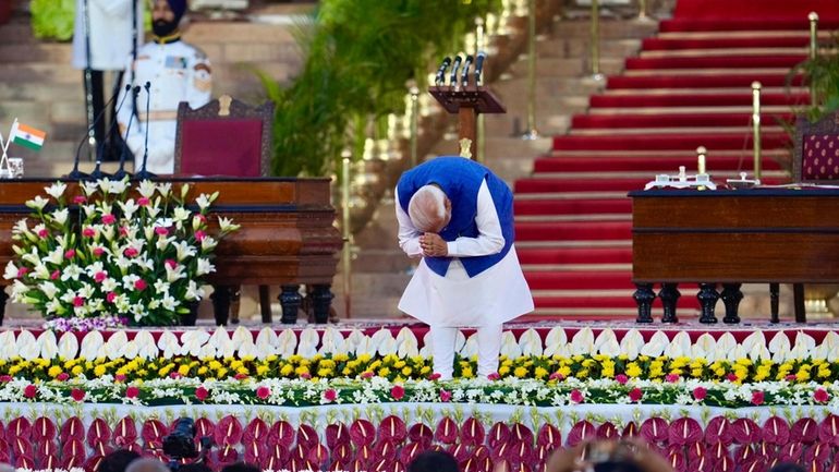 Narendra Modi greets the gathering as he arrives to take...