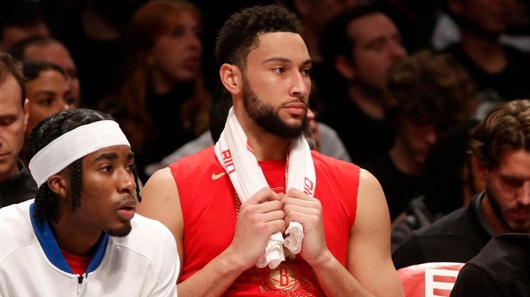 Ben Simmons of the Nets looks on from the bench in...