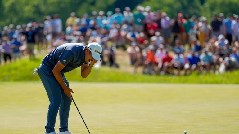 Collin Morikawa reacts after missing a putt on the seventh...