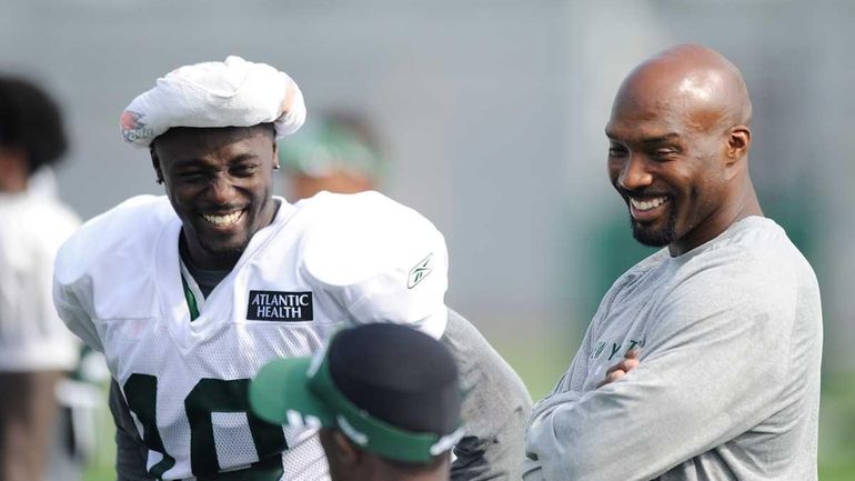 Santonio Holmes of the New York Jets (L) talks with...