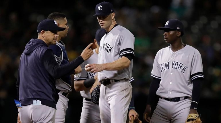 Yankees pitcher J.A. Happ hands the ball to manager Aaron...
