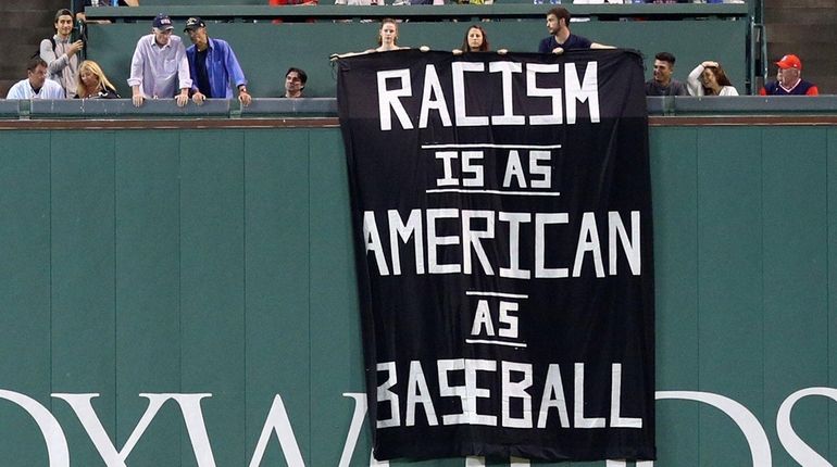 A banner with the message "Racism is as American as...