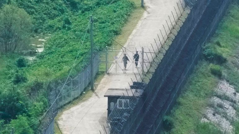 South Korean army soldiers patrol along the barbed-wire fence in...