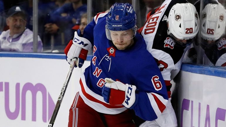 Zac Jones of the Rangers checks Michael McLeod #20 of the...