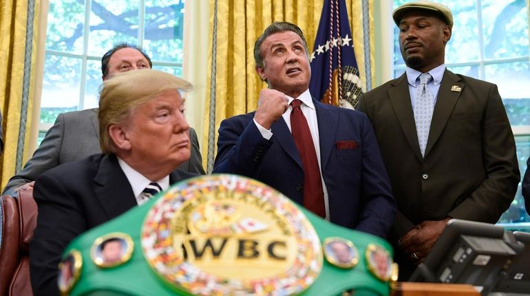 Actor Sylvester Stallone, center, with heavyweight champion boxer Lennox Lewis, right,...